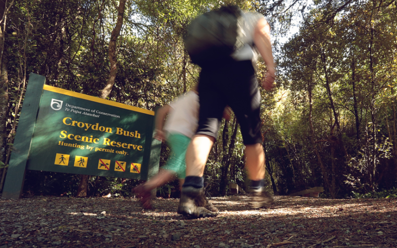 People walking past the Croydon Bush Scenic Reserve sign